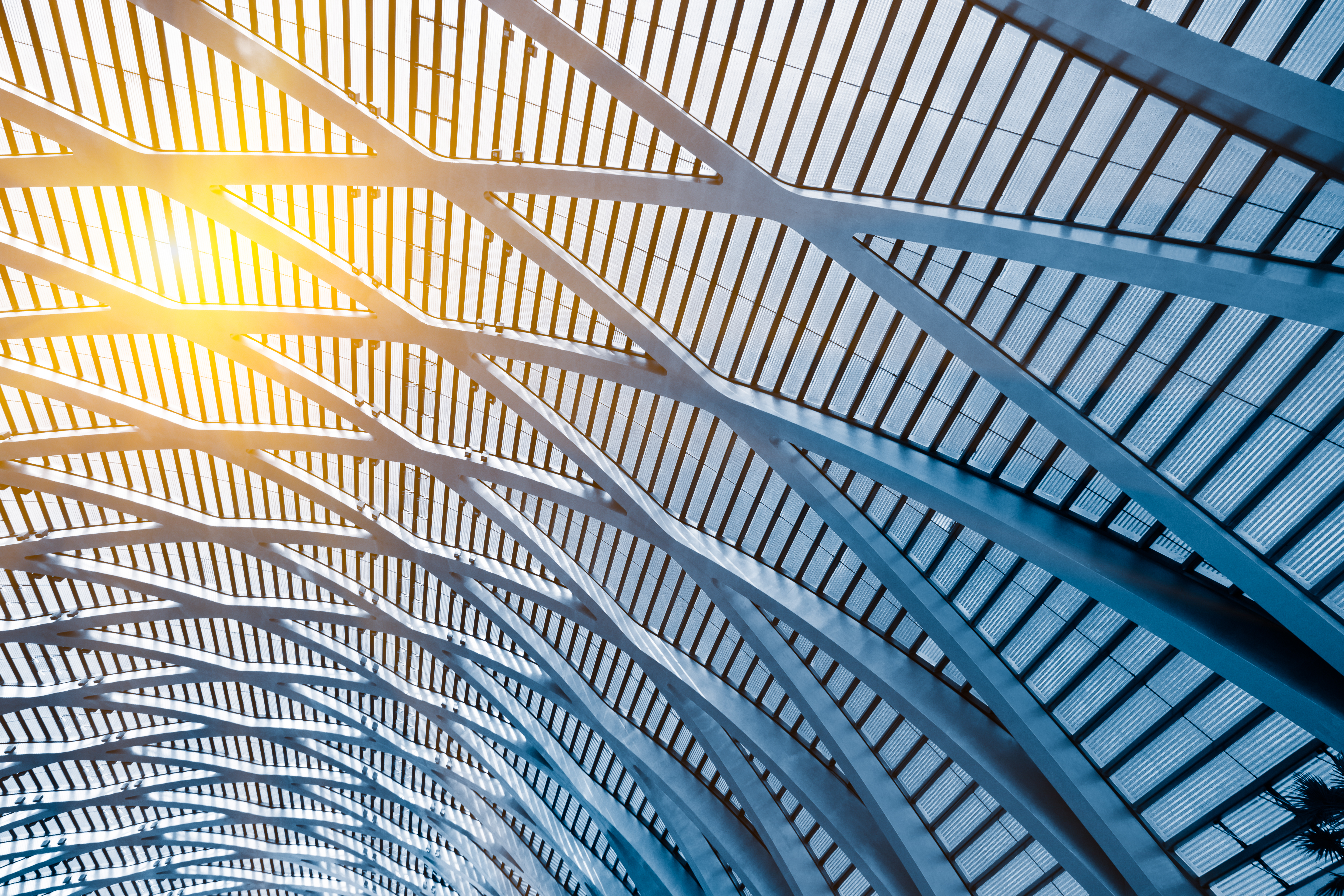 Warm metal ceiling with intersecting structural beams forming a subtle geometric grid